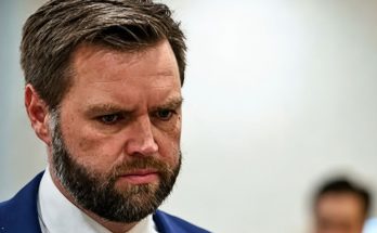 serious man in suit looking down in a focused setting