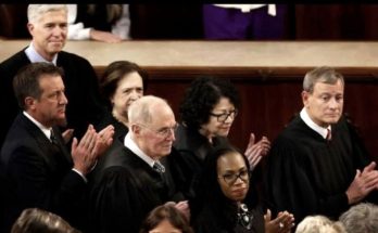 Group of people in judicial robes clapping in a courtroom