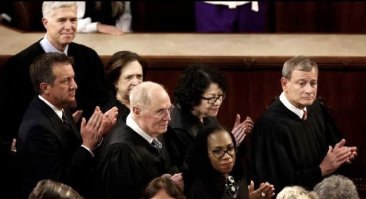 Group of people in judicial robes clapping in a courtroom